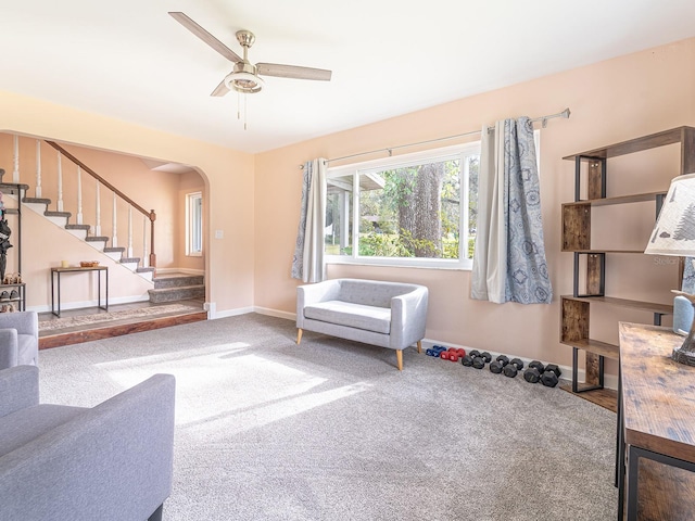 carpeted living room with ceiling fan