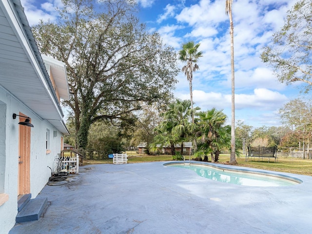 view of pool with a patio area and a trampoline