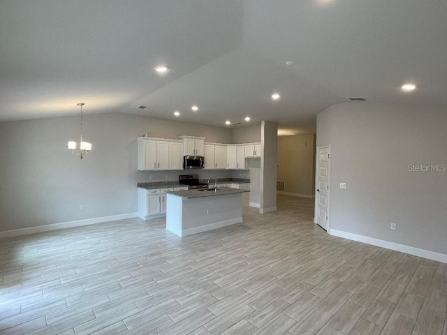 kitchen featuring lofted ceiling, a kitchen island with sink, appliances with stainless steel finishes, and white cabinetry