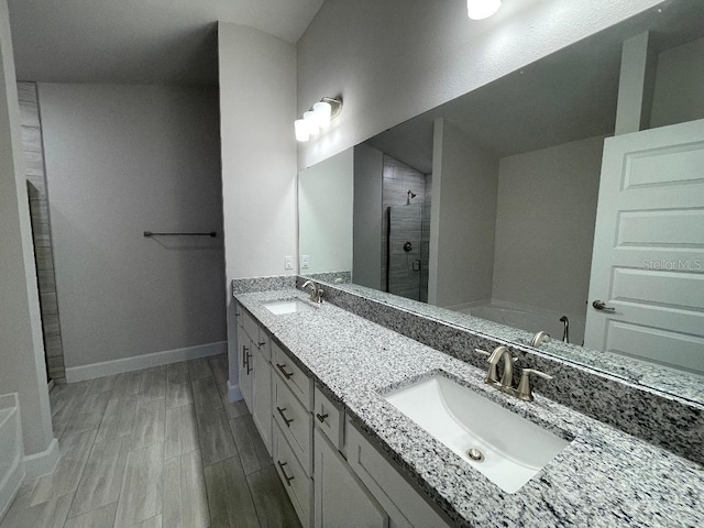 bathroom featuring hardwood / wood-style flooring, walk in shower, and vanity