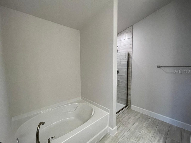 bathroom featuring vaulted ceiling and independent shower and bath