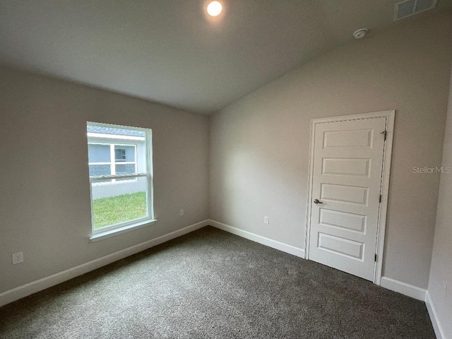 carpeted empty room with lofted ceiling