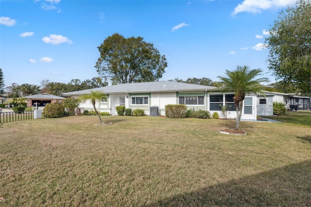 rear view of house with central AC and a yard