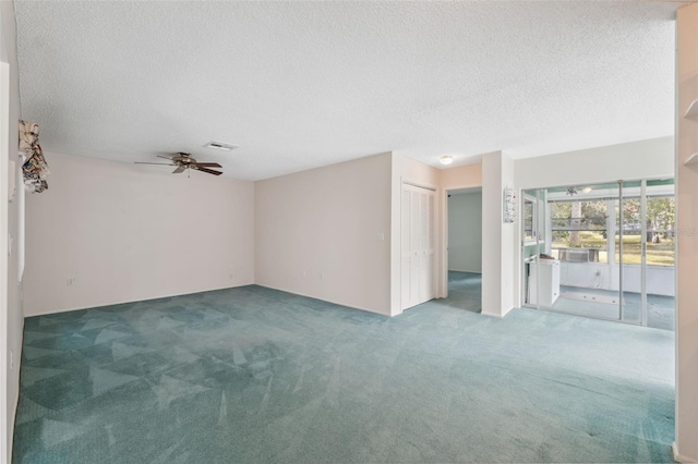 carpeted spare room featuring a textured ceiling and ceiling fan