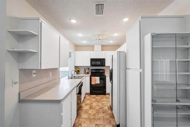 kitchen featuring a textured ceiling, white cabinets, and black appliances