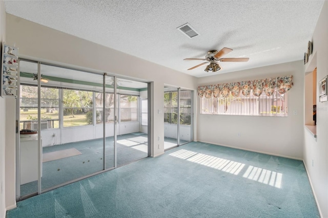 unfurnished room featuring ceiling fan, light carpet, and a textured ceiling