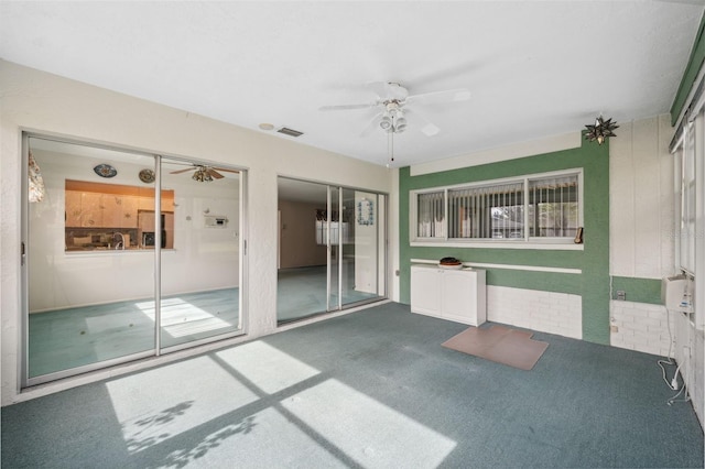 unfurnished sunroom featuring ceiling fan and a healthy amount of sunlight