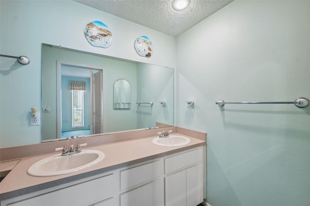 bathroom featuring a textured ceiling and vanity