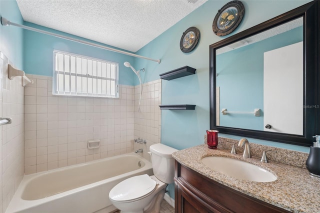 full bathroom featuring a textured ceiling, toilet, vanity, and tiled shower / bath