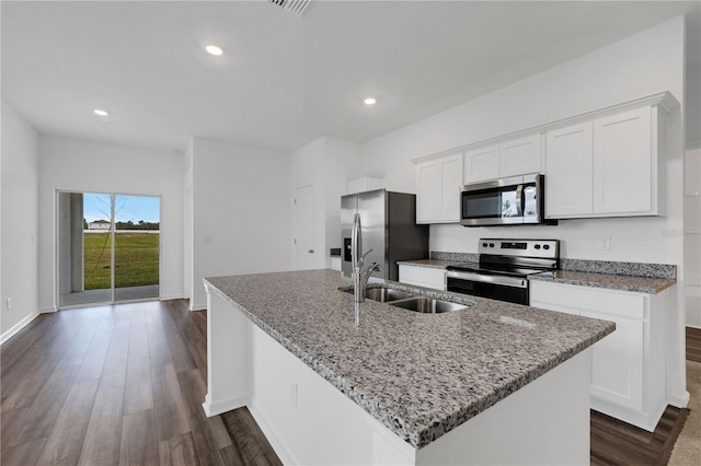 kitchen with white cabinets, sink, stainless steel appliances, and a center island with sink