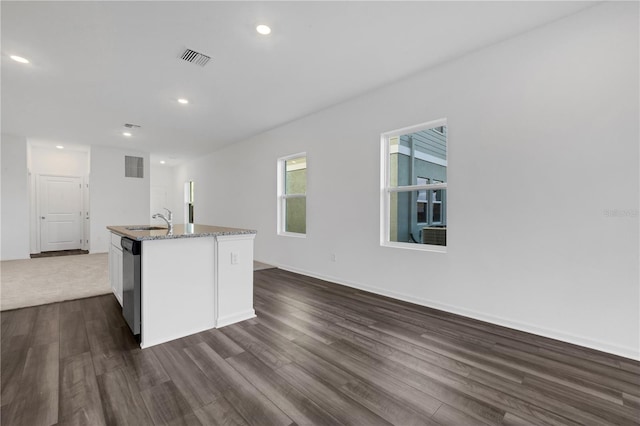 kitchen featuring sink, a kitchen island with sink, dishwasher, and dark hardwood / wood-style flooring