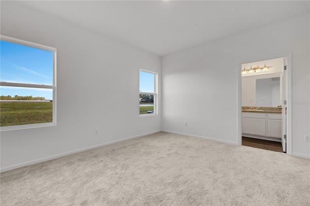 unfurnished bedroom featuring carpet flooring and ensuite bath