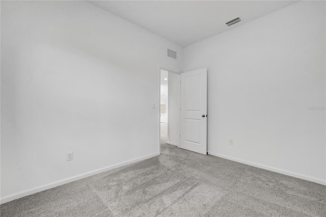 spare room featuring light colored carpet