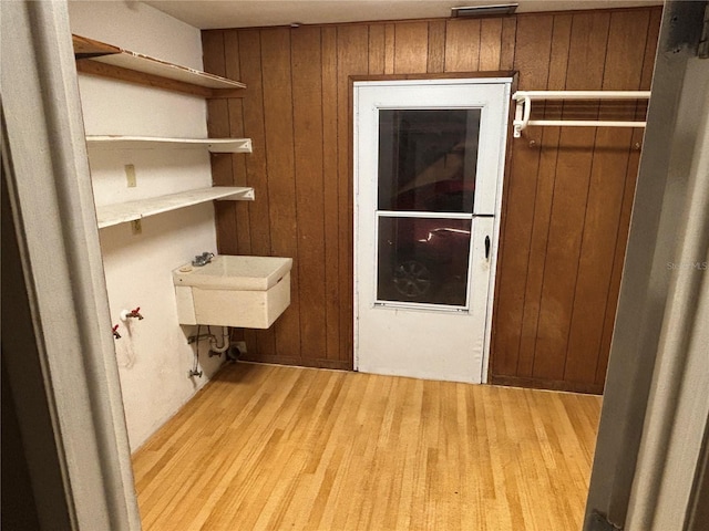 laundry room featuring wooden walls and sink