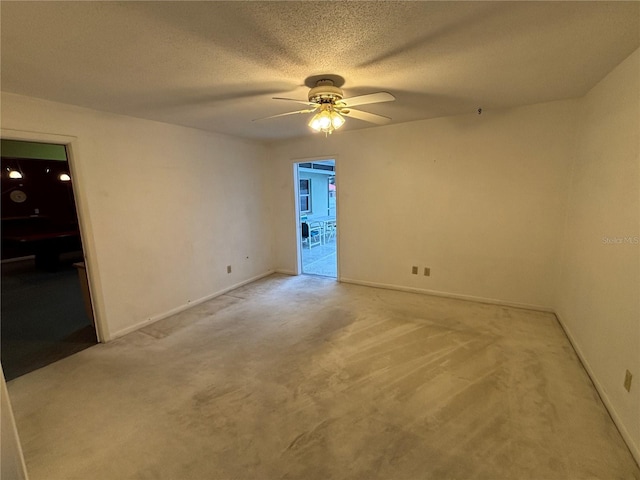 spare room with carpet floors, ceiling fan, and a textured ceiling