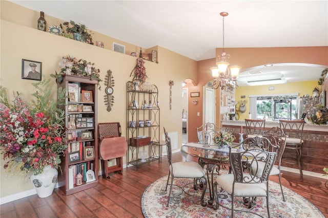 dining room featuring a wall unit AC, dark hardwood / wood-style flooring, and a notable chandelier