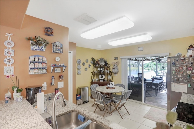 dining area featuring light tile patterned floors and sink