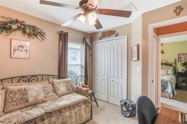 carpeted bedroom with ceiling fan and a closet