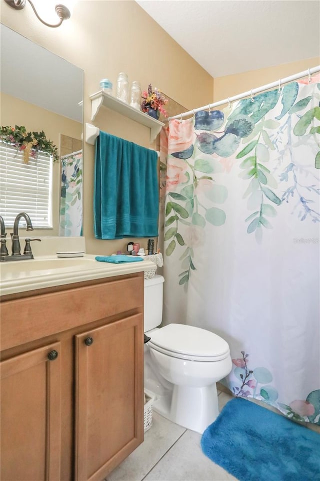 bathroom with toilet, tile patterned flooring, and vanity