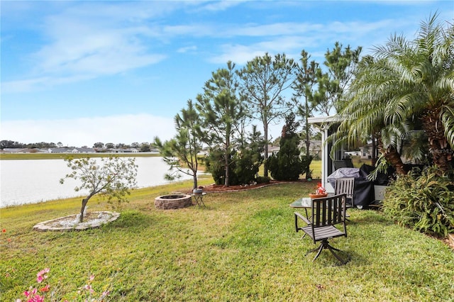 view of yard with a water view and a fire pit