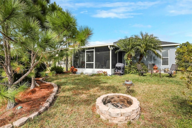 view of yard featuring a fire pit and a sunroom