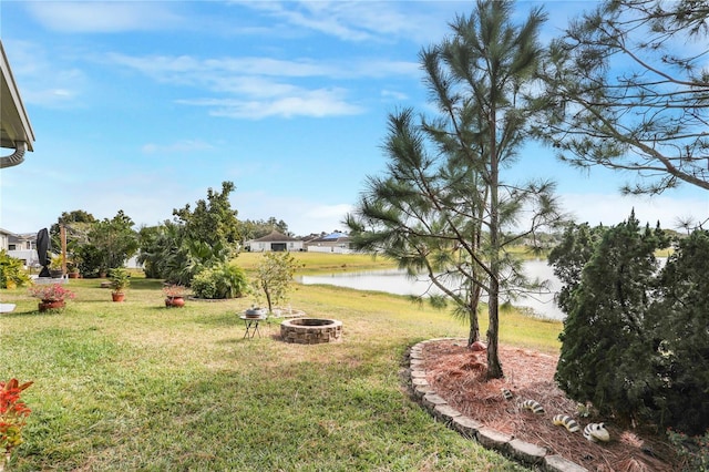 view of yard with a water view and a fire pit