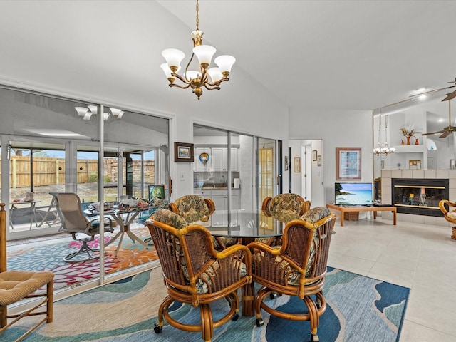 dining area featuring lofted ceiling, a chandelier, light tile patterned floors, and a fireplace