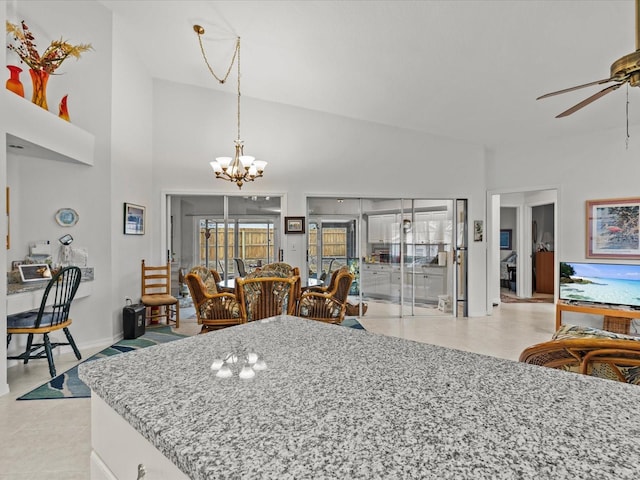 kitchen featuring white cabinetry, light stone countertops, ceiling fan with notable chandelier, and decorative light fixtures