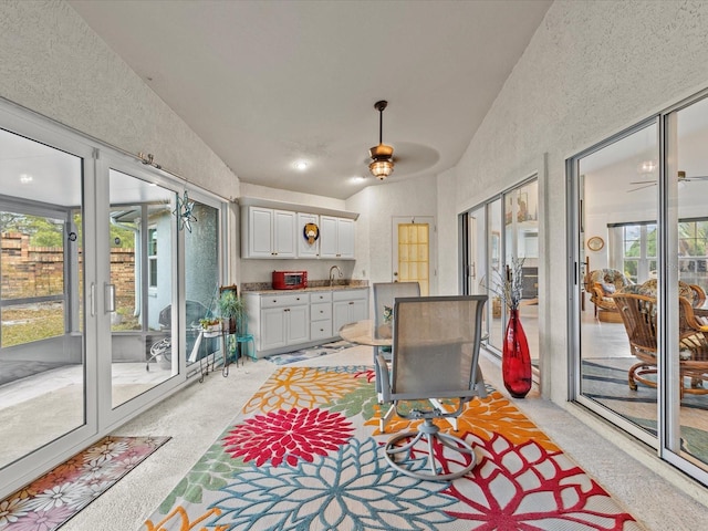 sunroom featuring lofted ceiling and sink