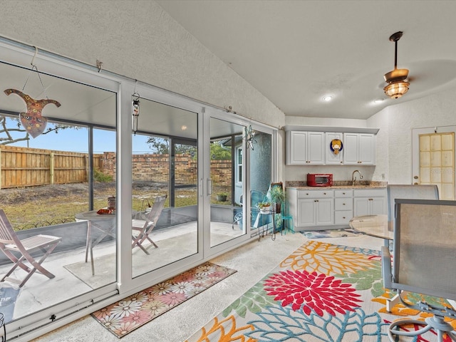 interior space with lofted ceiling, sink, and light carpet