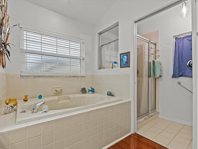 bathroom featuring tile patterned floors, shower with separate bathtub, and vaulted ceiling