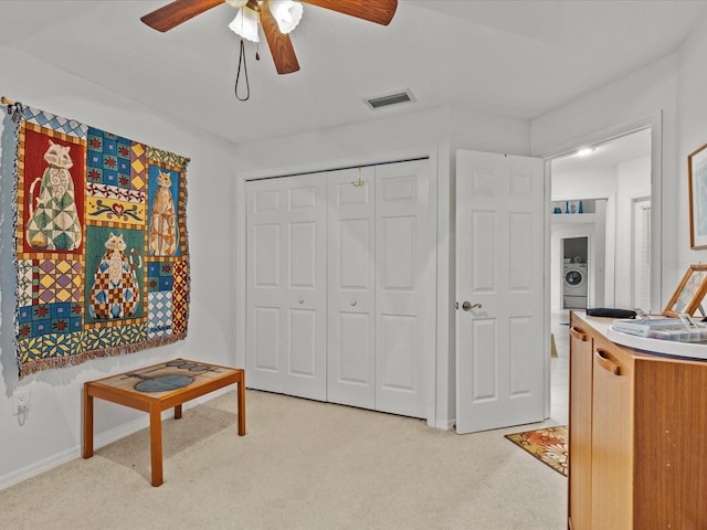 interior space featuring ceiling fan, washer / dryer, and a closet