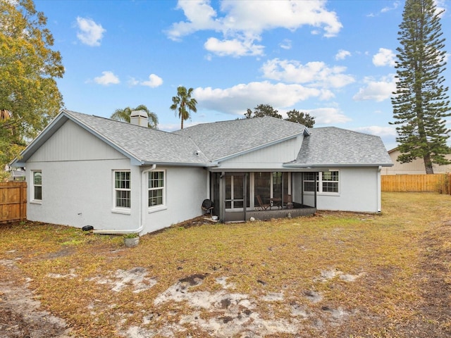 back of house with a lawn and a sunroom