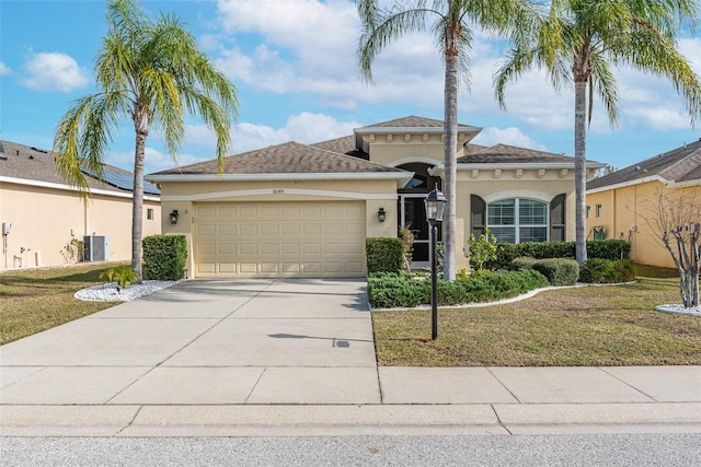 view of front of home with a garage, central AC, and a front yard