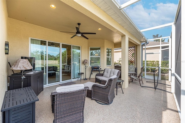 view of patio / terrace featuring ceiling fan, glass enclosure, and outdoor lounge area