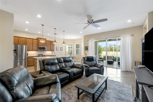 tiled living room with ceiling fan and sink