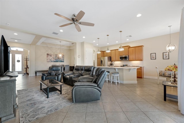 living room featuring ceiling fan with notable chandelier and light tile patterned floors