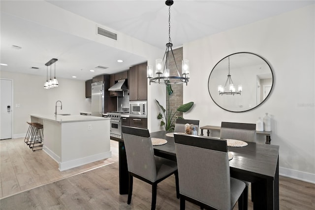 dining area with light wood-type flooring and sink