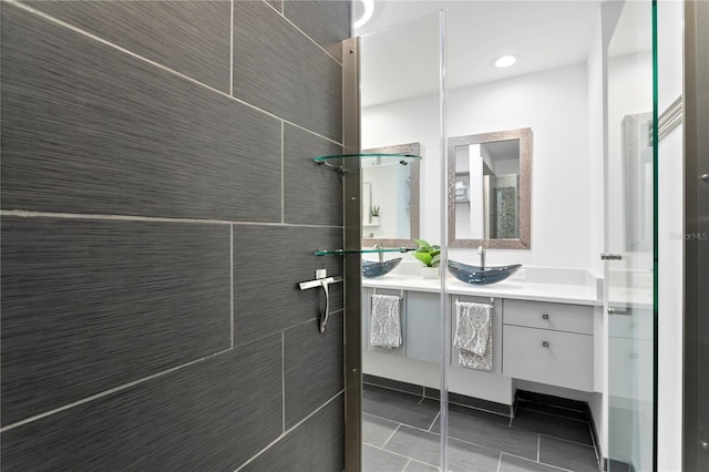 bathroom with vanity, tile patterned flooring, and tiled shower