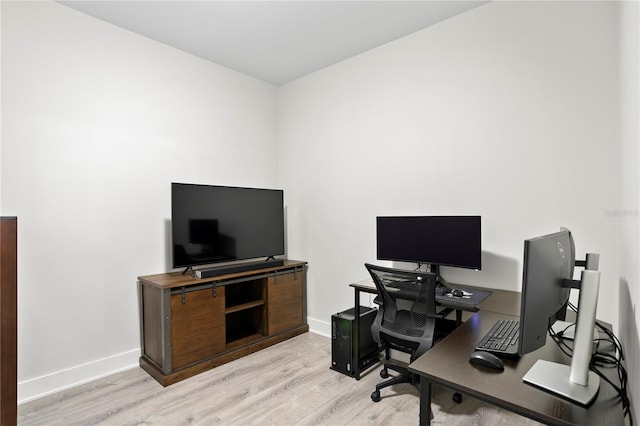 home office with light hardwood / wood-style flooring