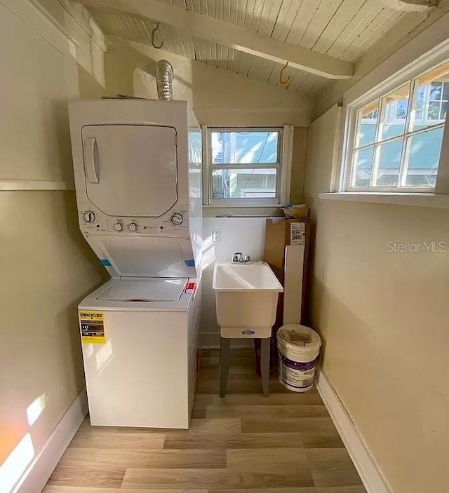 laundry area with stacked washer and dryer, wood ceiling, sink, and light hardwood / wood-style floors