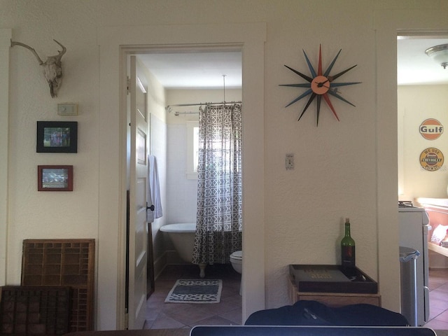 bathroom featuring toilet, a bathing tub, and tile patterned floors