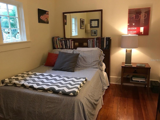 bedroom with dark hardwood / wood-style flooring