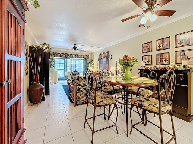 dining space with ceiling fan, light tile patterned floors, and crown molding