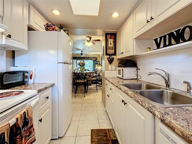 kitchen with light stone countertops, white cabinetry, tasteful backsplash, sink, and light tile patterned flooring