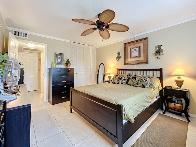 bedroom featuring ceiling fan, light tile patterned floors, a closet, and ornamental molding