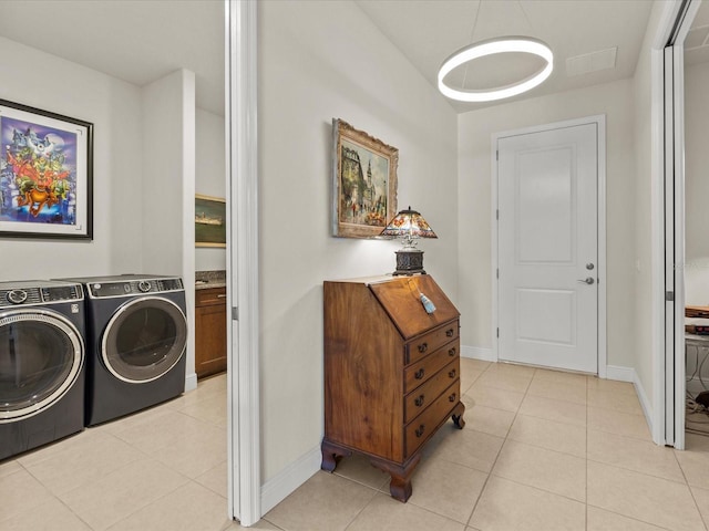 laundry room with washing machine and clothes dryer and light tile patterned flooring