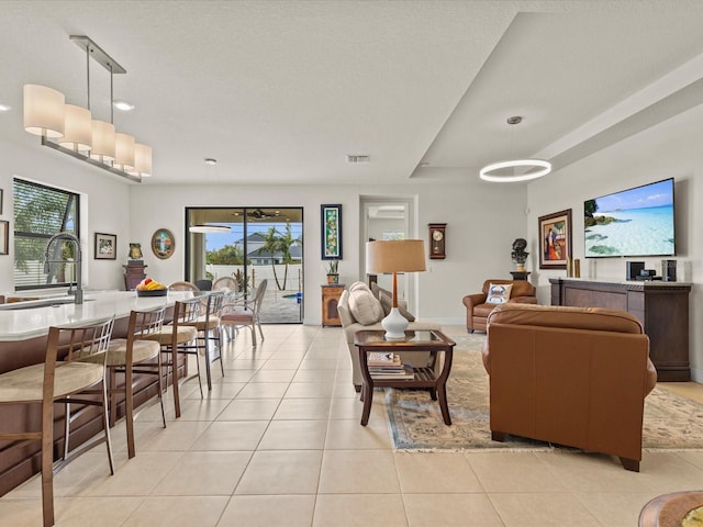 tiled living room featuring plenty of natural light and sink