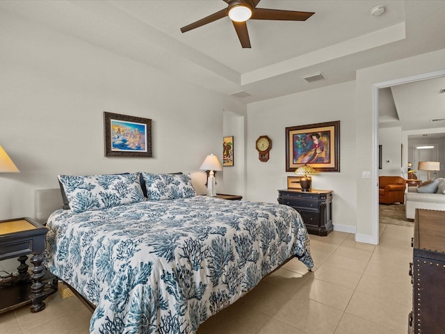 tiled bedroom with a raised ceiling and ceiling fan