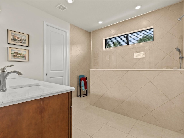 bathroom featuring vanity, tiled shower, and tile patterned floors